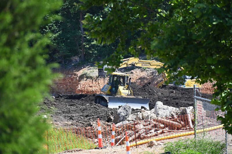 NWA Democrat-Gazette/SPENCER TIREY Workers use a bulldozer Thursday to smooth and fill the former stump dump after extinguishing a fire, while cleaning up in Bella Vista. Work is being done to stabilize the site now that the fire is out, according to the Property Owners Association.