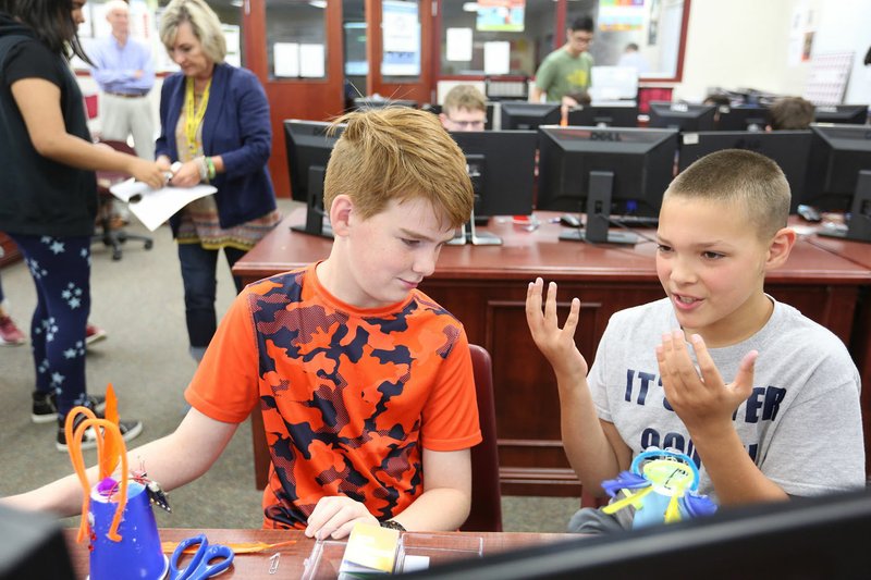 NWA Democrat-Gazette/DAVID GOTTSCHALK Phoenix Sosebee (right), a sixth grade student, describes Wednesday, June 11, 2019, the idea behind his Micro Bit Creature to Chad McDowell, also a sixth grade student, during the Bulldog It Up IT Camp at Springdale High School. Students in sixth through eighth grades had the opportunity to work with Springdale High School information technology students and teachers during the week long class.