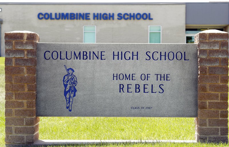 Signs outside Columbine High School are photographed, Thursday, June 13, 2019, in Littleton, Colo. The school district is considering the demolition of Columbine, the scene of a mass assault more than 20 years ago, and rebuilding the current school. (AP Photo/David Zalubowski)
