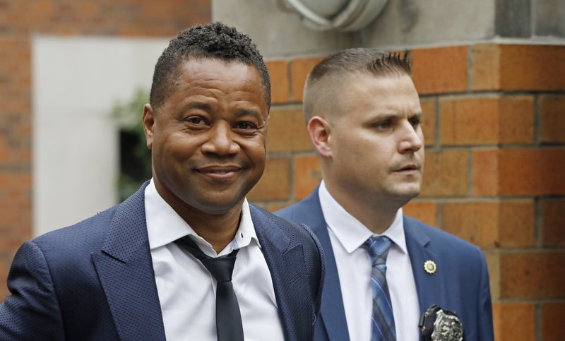 Actor Cuba Gooding Jr., left, is lead by a police officer from New York's Special Victim's Unit, Thursday, June 13, 2019. 