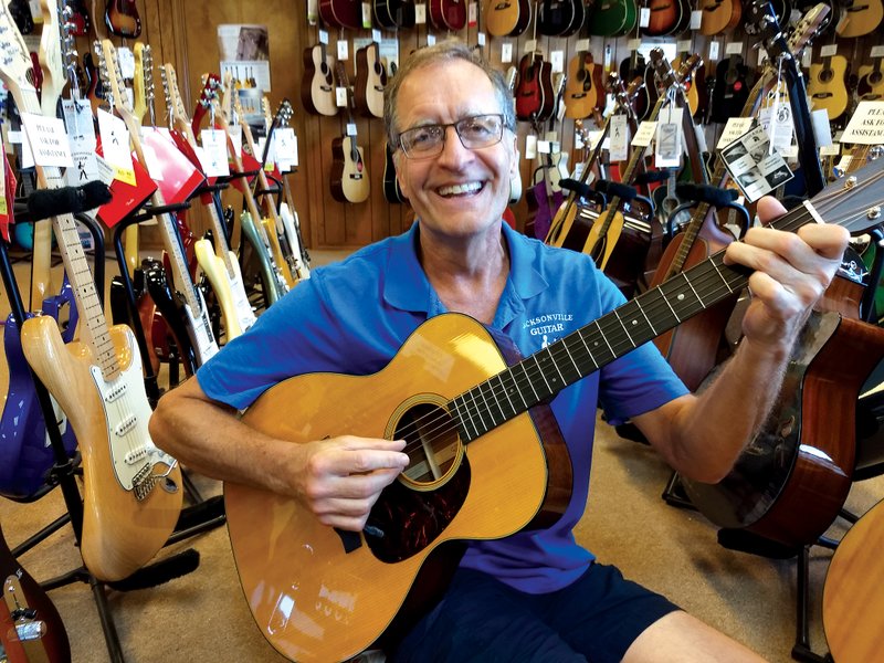 Holding his favorite acoustic guitar, Jacksonville Guitar Center owner Steve Evans tells stories of his 40-plus years in the retail music business. He’s set to sell his store, which includes his guitar museum, and retire later this year.