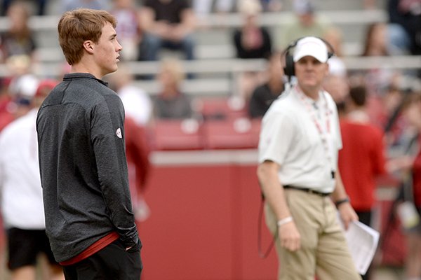 Chandler Morris (left), son of Arkansas coach Chad Morris (right), watches Saturday, April 6, 2019, during the Razorbacks' spring game in Razorback Stadium in Fayetteville. 