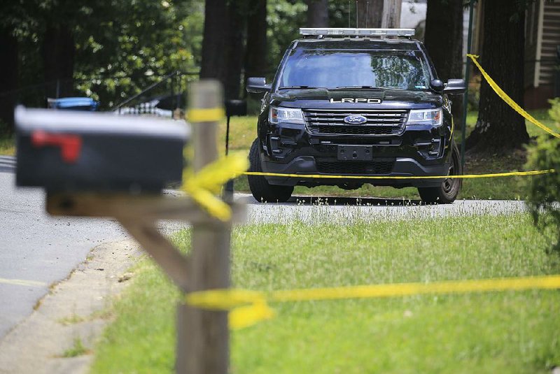 Police officers keep watch Friday at  the house at 4601 W. 16th St. in Little Rock where three women were found dead Thursday afternoon.