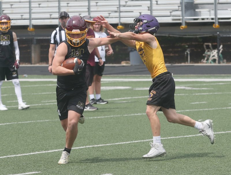The Sentinel-Record/Richard Rasmussen STIFF ARM: Lake Hamilton rising sophomore Owen Miller, left, pushes past Fountain Lake rising junior Jack Wurz defends during pool play of Fountain Lake's 7-on-7 tournament Friday. Fountain Lake finished second, and Lake Hamilton was third.