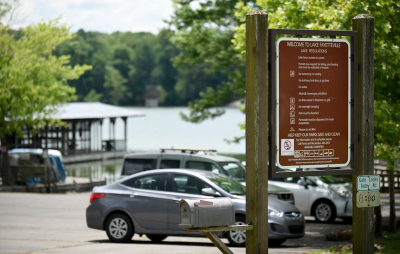 NWA Democrat-Gazette/DAVID GOTTSCHALK Signs list lake regulations at Lake Fayetteville. City officials were notified June 7 test results from the lake showed 15 micrograms per liter of microcystin. On Friday, Brian Haggard, director of the Arkansas Water Resources Center of the University of Arkansas System's Division of Agriculture, told city officials the levels were below the threshold for public notification.