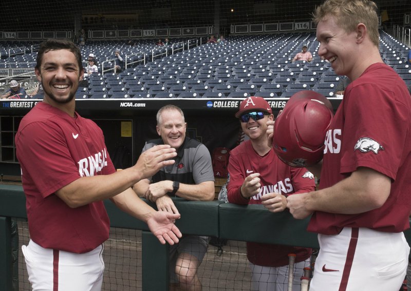 NWA Democrat-Gazette/Charlie Kaijo LAUGHING BREAK: Arkansas director of athletics Hunter Yurachek, second from left, laughs with Razorbacks outfielders Dominic Fletcher, left, and Heston Kjerstad, right, during a practice Friday at the TD Ameritrade Park in Omaha, Neb.