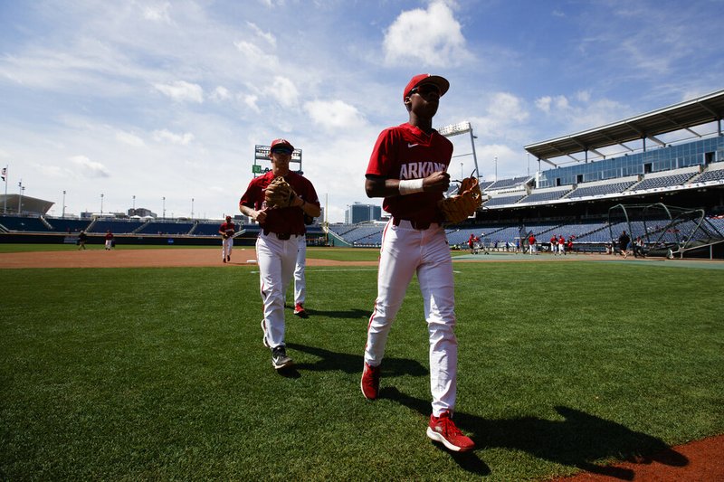 Arkansas' Curtis Washington, Jr., right, and Casey Martin head to the dugout during practice for baseball's College World Series at TD Ameritrade Park, Friday, June 14, 2019, in Omaha, Neb. (Ryan Soderlin/Omaha World-Herald via AP)