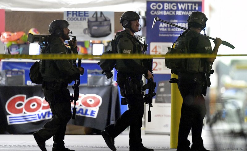 Heavily armed police officers exit the Costco following a shooting inside the wholesale warehouse in Corona, Calif., Friday, June 14, 2019. A gunman opened fire inside the store during an argument, killing a man, wounding two other people and sparking a stampede of terrified shoppers before he was taken into custody, police said. The man involved in the argument was killed and two other people were wounded, Corona police Lt. Jeff Edwards said. (Will Lester/Inland Valley Daily Bulletin/SCNG via AP)