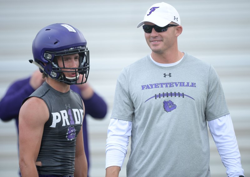 New Fayetteville coach Casey Dick speaks Saturday, June 15, 2019, with Bulldogs receiver Connor Flannigan during the Alma 7-on-7 Showcase football tournament at Citizens Bank Field in Alma.