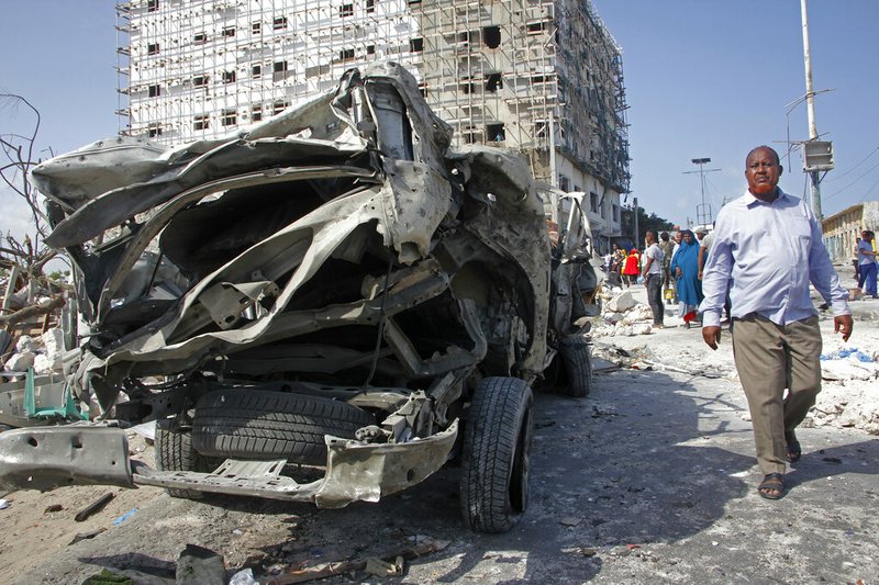 A man walks past the wreckage of an official vehicle that was destroyed in a bomb attack in the capital Mogadishu, Somalia, Saturday, June 15, 2019. 