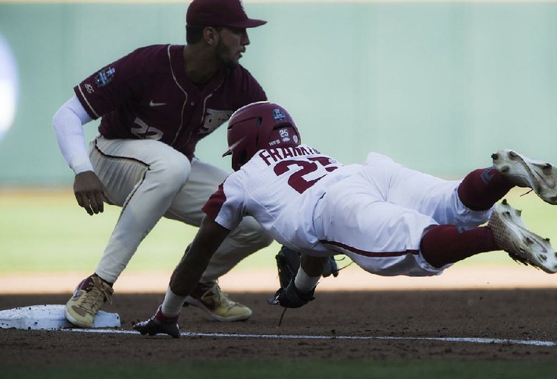 Arkansas’ Christian Franklin (right) is doubled off third base by Florida State’s Drew Mendoza after Matt Goodheart’s lineout during the third inning of the Razorbacks’ loss to the Seminoles on Saturday during the College World Series at TD Ameritrade Park in Omaha, Neb. See more photos at arkansasonline.com/galleries.
