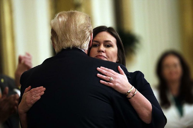 Press secretary Sarah Huckabee Sanders receives a hug from President Donald Trump in the East Room of the White House on Thursday after her plans to leave the administration were announced.