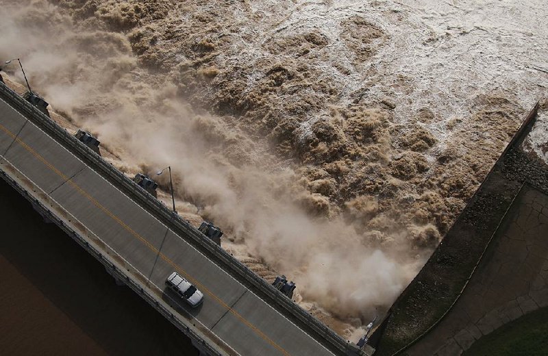 Excess water pours out of the dam on Keystone Lake northwest of Tulsa on May 24. The U.S. Army Corps of Engineers released millions of gallons of water from rain-swollen Oklahoma reservoirs into the Arkansas River, causing severe flooding in Arkansas. Gov. Asa Hutchinson is calling for a review of how the release was handled. 