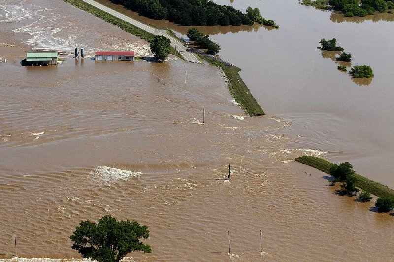 FILE — Floodwaters from the Arkansas River pour through a breach in the Dardanelle Levee on May 31. 