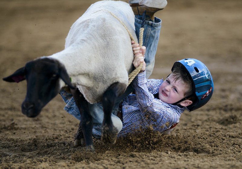 File Photo/CHARLIE KAIJO Ryder Kirk, 5, of Prairie Grove rides in the mutton bustin' event during the 74th annual Rodeo of the Ozarks in 2018. Mutton bustin' starts at 6:30 p.m. daily during the 75th annual Rodeo of the Ozarks, coming up June 26-29 in Springdale. Up to 25 children may participate in mutton bustin' each night.
