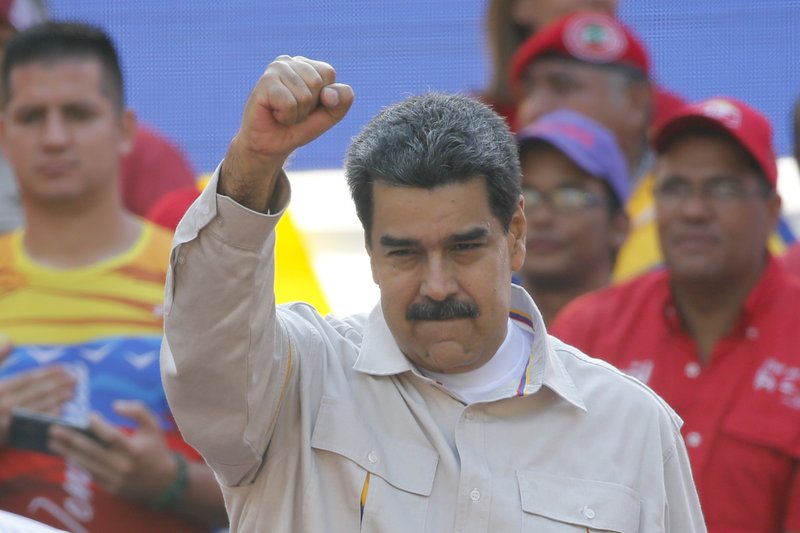 In this April 6, 2019 file photo, Venezuela's President Nicolas Maduro raises his fist to supporters rallying at the presidential palace in Caracas, Venezuela. The Associated Press has learned on Saturday, June 15, 2019, that major European nations are considering imposing sanctions on Maduro and several top officials for their recent crackdown on political opponents. (AP Photo/Ariana Cubillos, File)