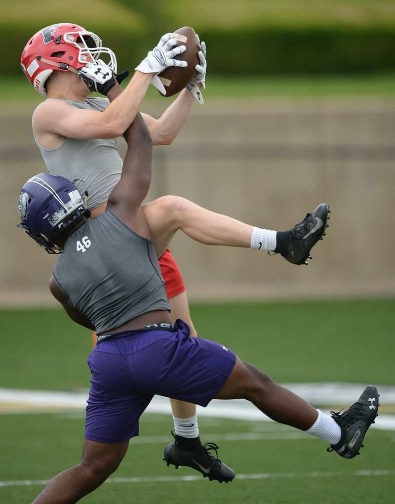 NWA Democrat-Gazette/ANDY SHUPE Farmington receiver Drew Sturgeon (top) pulls down a pass Saturday, June 15, 2019, over Fayetteville's Lamont Bliss during the Alma 7-on-7 Showcase football tournament at Citizens Bank Field in Alma.