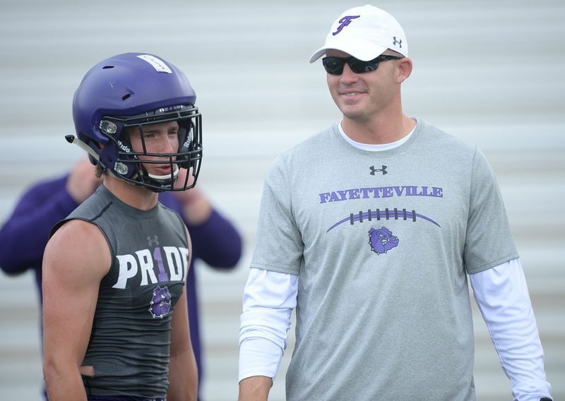NWA Democrat-Gazette/ANDY SHUPE New Fayetteville coach Casey Dick speaks Saturday, June 15, 2019, with Bulldogs receiver Connor Flannigan during the Alma 7-on-7 Showcase football tournament at Citizens Bank Field in Alma.