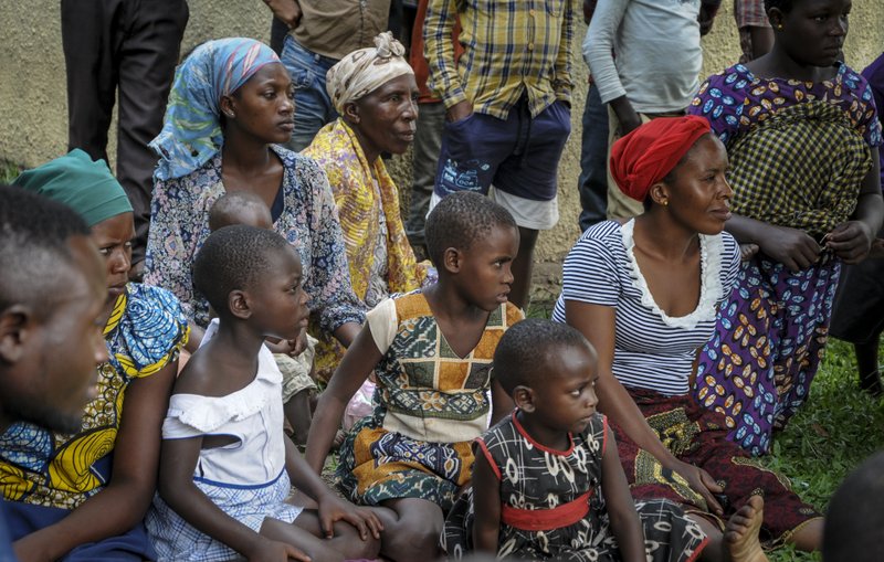 Relatives of the 5-year-old boy who became Ebola's first cross-border victim, and other villagers, listen as village leaders and health workers educate them about Ebola symptoms and prevention, in the village of Kirembo, near the border with Congo, in western Uganda Saturday, June 15, 2019. The World Health Organization (WHO) in Uganda said Saturday that it has started ring vaccination of all contacts of the confirmed Ebola cases including health workers. (AP Photo/Ronald Kabuubi)