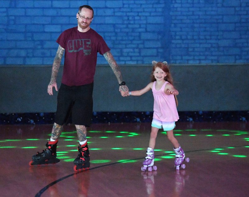 James Chapracki of Fayetteville skates Sunday with his daughter Ruby Chapracki, 6, Sunda at Starlight Skatium in Fayetteville. Dads got to skate for free Sunday for Father's Day. NWA Democrat-Gazette/J.T. WAMPLER
