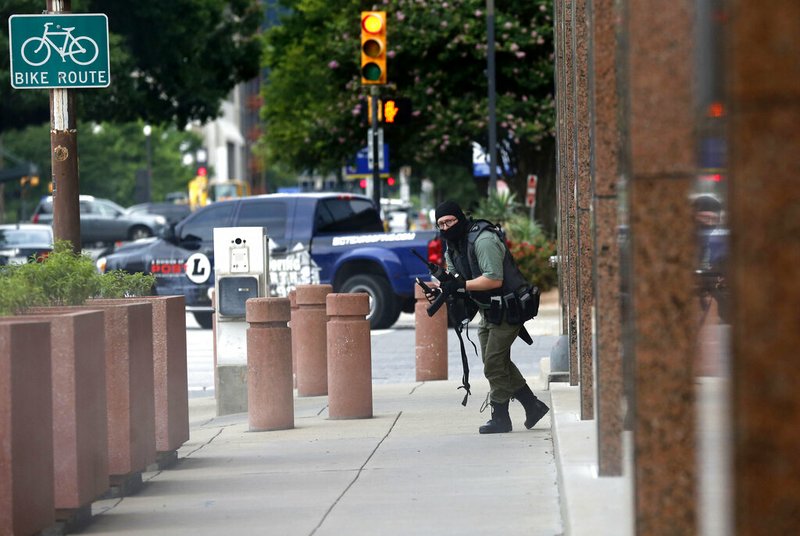 An armed shooter stands near the Earle Cabell Federal Building Monday, June 17, 2019, in downtown Dallas. The shooter was hit and injured in an exchange of gunfire with federal officers outside the courthouse. (Tom Fox/The Dallas Morning News)