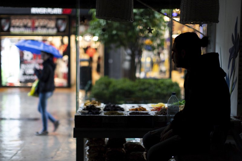A pedestrian with an umbrella walks past a health food store which is still without electricity, in Buenos Aires, Argentina, Monday, June 17, 2019. As lights turned back on across Argentina, Uruguay and Paraguay after a massive blackout that hit tens of millions people, authorities were still largely in the dark about what caused the collapse of the interconnected grid and were tallying the damage from the unforeseen disaster.