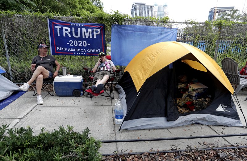 Anna Connelly, left, and Jeanna Gullett supporters of President Donald Trump, make camp Monday, June 17, 2019, in Orlando, Fla. as they wait to attend a rally for the president on Tuesday evening.