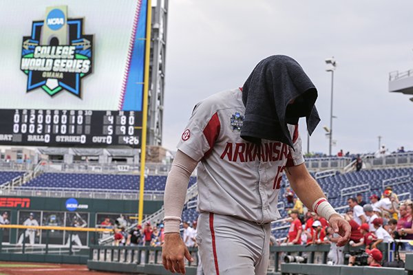 Arkansas catcher Casey Opitz (12) covers his head as he walks off the field following an NCAA College World Series baseball game against Texas Techin Omaha, Neb., Monday, June 17, 2019. Texas Tech won 5-4. (AP Photo/Nati Harnik)

