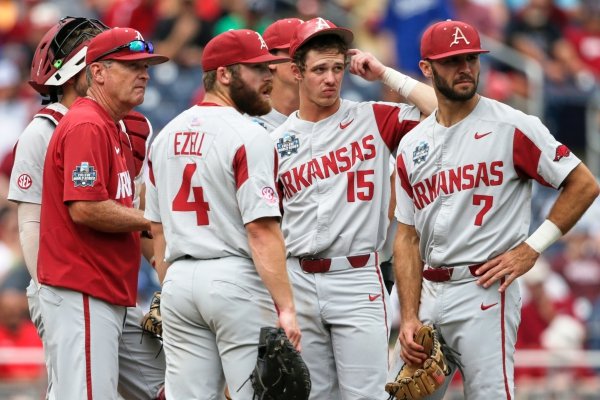 Arkansas coach Dave Van Horn, left, and players wait on the mound for new pitcher Jacob Kostyshock to arrive from the bullpen, in the seventh inning of an NCAA College World Series baseball game against Texas Tech, in Omaha, Neb., Monday, June 17, 2019. Texas Tech won 5-4. (AP Photo/Nati Harnik)