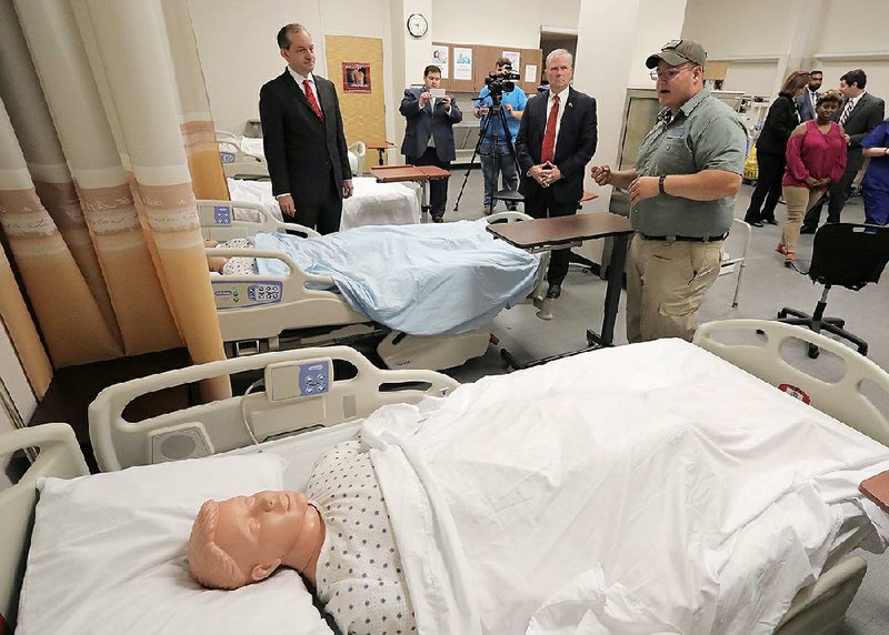 U.S. Labor Secretary Alexander Acosta (left) and Lt. Gov. Tim Griffin (middle) listen to Jessup Grogan, a medical professions program graduate, during a tour of the North Little Rock School District’s Center of Excellence on Monday morning. 