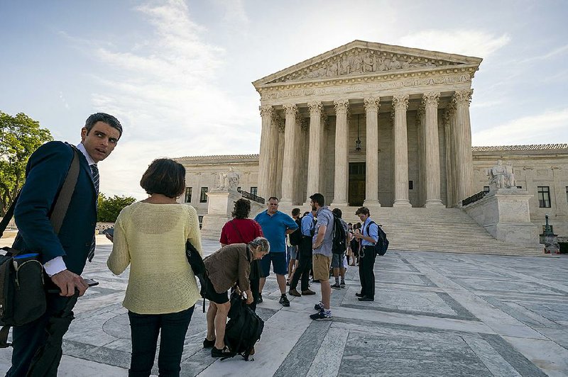 People gather outside the Supreme Court in Washington as they wait for justices to hand down decisions Monday.