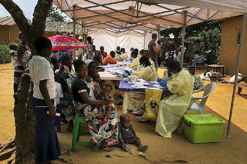 People wait to receive Ebola vaccinations Monday in the village of Mabalako, Congo. Health officials in eastern Congo have be- gun offering the vaccinations to all residents of Mabalako, a hot spot in an Ebola outbreak that has killed more than 1,400 people.