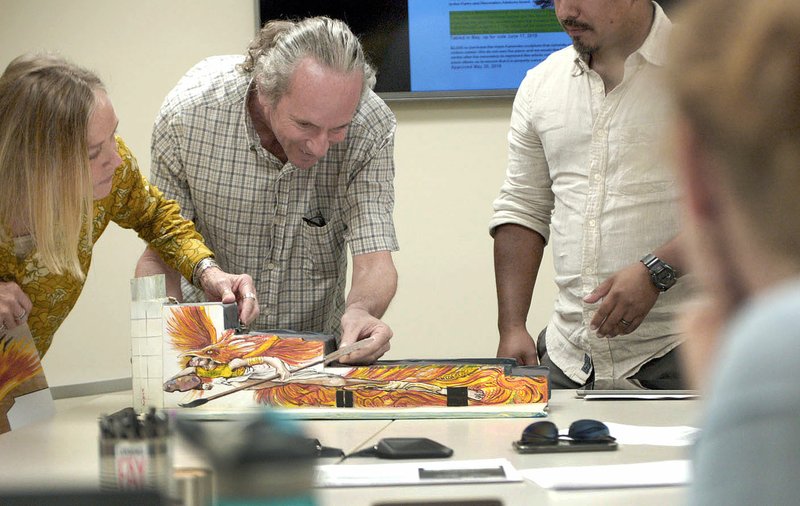 NWA Democrat-Gazette/STACY RYBURN Jeanne Parham (left), Eugene Sargent and Octavio Logo with the artist collective Fenix Fayetteville on Monday show a model of a mural proposed in the alley between the Fenix building and Arvest Bank on the downtown square. The Fayetteville Advertising and Promotion Commission approved putting $10,000 toward the project.