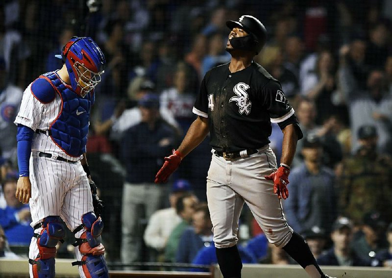 Eloy Jimenez (right) of the Chicago White Sox celebrates as he crosses home plate in front of Chicago Cubs catcher Victor Caratini after hitting a two-run home run in the ninth inning of the White Sox’s 3-1 victory Tuesday night. 