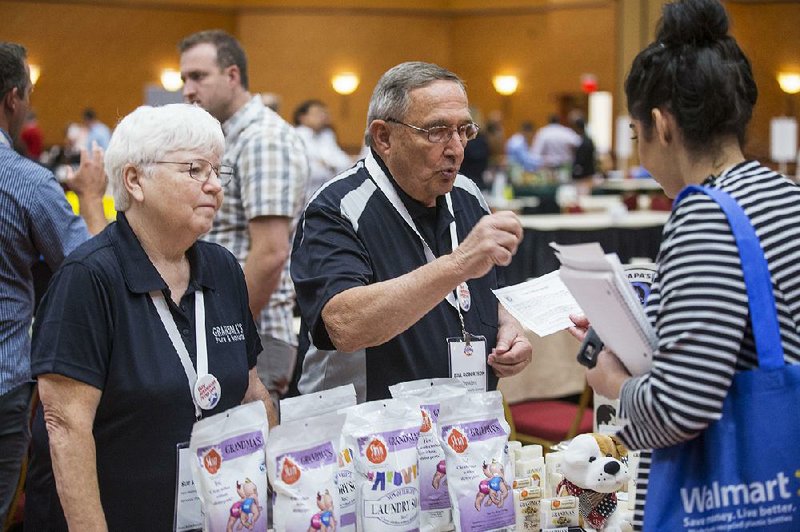 Bill and Sue Robertson, owners of Grandma’s Pure & Natural based in Tulsa, talk about their handmade soaps Tuesday with Rayanna Azar (right), who works in personal care and beauty product development for Walmart. Tuesday was the first day of Walmart’s annual Open Call event in Rogers.