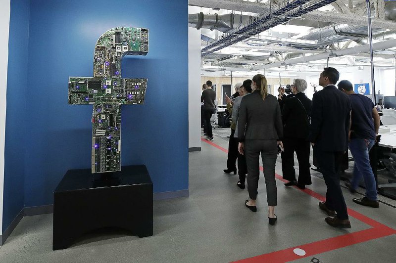 Members of the media and guests tour Facebook’s offices in Cambridge, Mass., earlier this year. The social network unveiled a plan Tuesday to create a new digital currency backed by 27 partners as diverse as Mastercard and Uber.