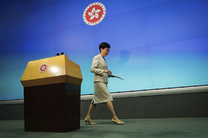 Hong Kong Chief Executive Carrie Lam leaves the stage Tuesday  after apologizing during a news conference before the Legislative  Council for pursuing a China extradition bill. 