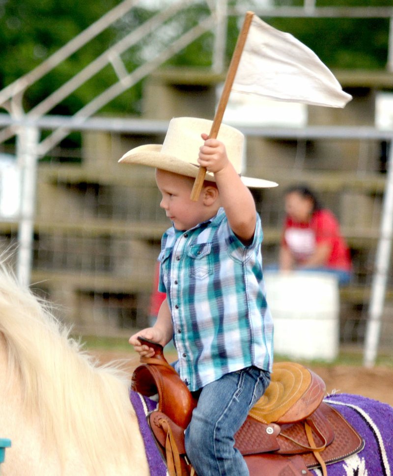 Adriana Jessen/Special to the Herald-Leader A young rider proudly held his flag while competing in a flag race at the Siloam Springs Riding Club on June 11. The recently upgraded rodeo grounds not only host annual rodeo, but also serve as a venue for events such as play nights and barrel races year round.