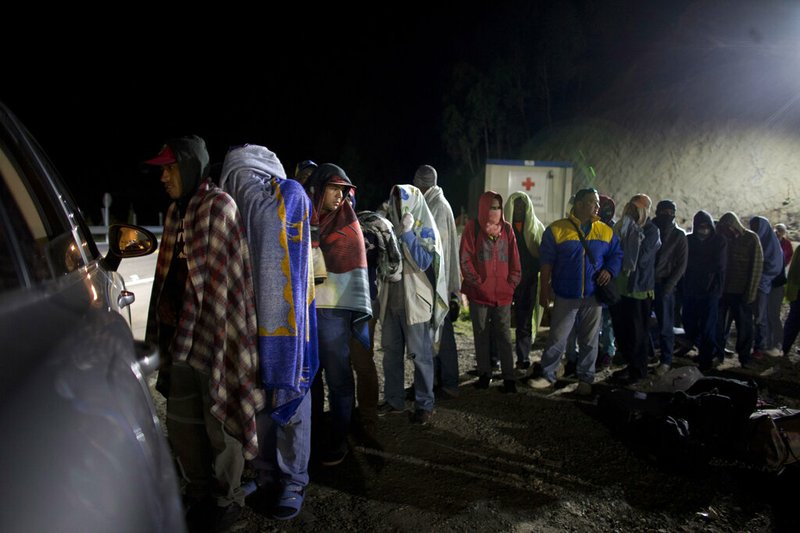 In this Aug. 31, 2018 file photo, Venezuelan migrants line up for free bread and coffee, donated by a Colombian family from their car, at a gas station in Pamplona, Colombia. A record 71 million people have been displaced worldwide from war, persecution and other violence, the U.N. refugee agency said Wednesday, June 18, 2019, an increase of more than 2 million from last year and an overall total that would amount to the world's 20th most populous country. Amid runaway inflation and political turmoil at home, Venezuelans for the first time accounted for the largest number of new asylum-seekers in 2018, with more than 340,000, or more than one in five worldwide last year. (AP Photo/Ariana Cubillos)