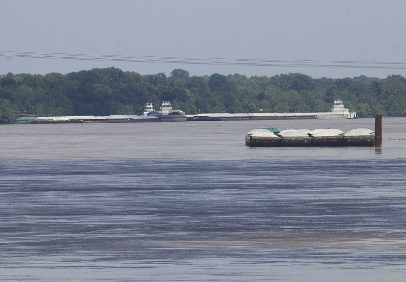 Barges sit idle May 23 on the flood-swollen Arkansas River near Little Rock. The river remains too high for officials to assess its navigability and “has changed dramatically,” Col. Robert Dixon of the U.S. Army Corps of Engineers said Wednesday. 