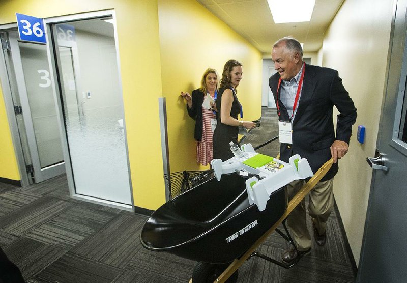 Bob Thorsen, managing partner of The Little Burros, wheels a sample of his Burro Buddy wheelbarrow accessory to a meeting with Walmart buyers Wednesday at Walmart’s annual Open Call event at Walmart headquarters in Bentonville. 