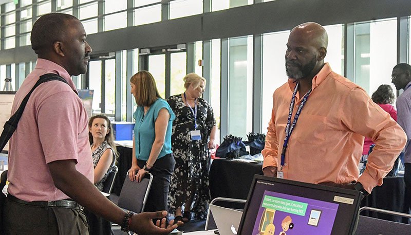 The Sentinel-Record/Grace Brown ATTENDEES: Todd Parker with the Arkansas Department of Education, left, speaks to Dexter Miller with Team Digital Arkansas during the first day of the 2019 Arkansas Department of Education Summit at the Hot Springs Convention Center on Tuesday.