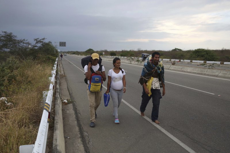 Venezuelan migrants walk on the Pan-American Highway, after crossing the Ecuadorian border into Tumbes, Peru, Friday, June, 14, 2019. Those fleeing the troubled South American nation filed more than one in five of all asylum requests made in 2018. That's higher than requests made by people escaping Afghanistan and Syria. (AP Photo/Martin Mejia)
