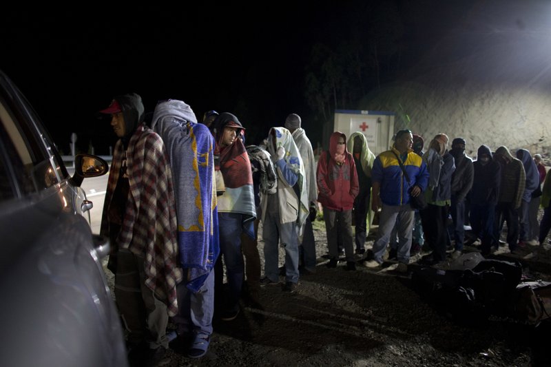 In this Aug. 31, 2018 file photo, Venezuelan migrants line up for free bread and coffee, donated by a Colombian family from their car, at a gas station in Pamplona, Colombia. A record 71 million people have been displaced worldwide from war, persecution and other violence, the U.N. refugee agency said Wednesday, June 18, 2019, an increase of more than 2 million from last year and an overall total that would amount to the world's 20th most populous country. Amid runaway inflation and political turmoil at home, Venezuelans for the first time accounted for the largest number of new asylum-seekers in 2018, with more than 340,000, or more than one in five worldwide last year. (AP Photo/Ariana Cubillos)