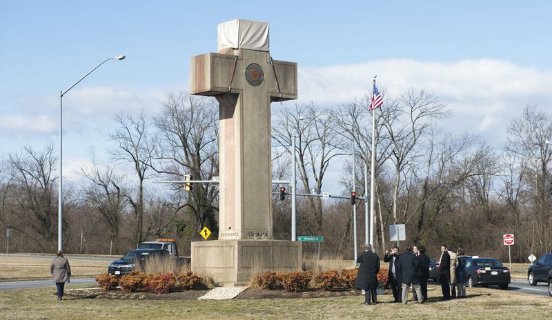 In this Feb. 13, 2019 file photo, visitors walk around the 40-foot Maryland Peace Cross dedicated to World War I soldiers in Bladensburg, Md. The Supreme Court says the World War I memorial in the shape of a 40-foot-tall cross can continue to stand on public land in Maryland. The high court on Thursday rejected a challenge to the nearly 100-year-old memorial. The justices ruled that its presence on public land doesn't violate the First Amendment's establishment clause. That clause prohibits the government from favoring one religion over others.(AP Photo/Kevin Wolf)