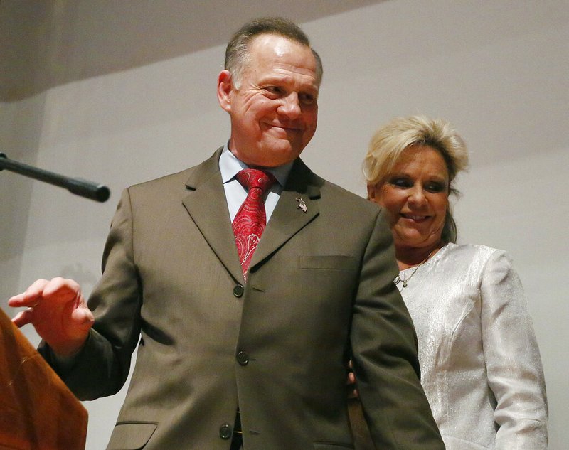 In this Tuesday, Dec. 12, 2017, file photo, Republican Senate candidate Roy Moore walks off the stage with wife Kayla Moore after he spoke to supporters after an election-night watch party at the RSA activity center, in Montgomery, Ala. Moore has scheduled a news conference, Thursday, June 20, 2019, to announce whether he is running for U.S. Senate in 2020. (AP Photo/Brynn Anderson, File)