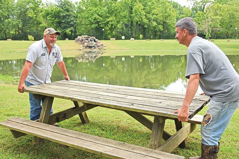 Charles Wilson, left, Clinton Street Department foreman, and Michael Todd, a Clinton Street Department laborer, move a picnic table by the fishing-derby pond. The 21st annual Archey Fest on Saturday will include a kids fishing derby, beginning at 6 p.m. at the stocked pond.