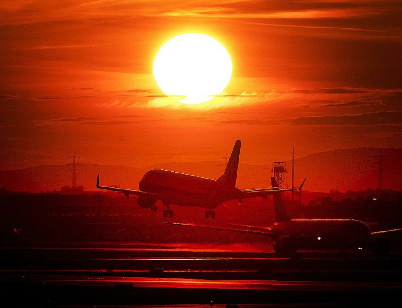 An aircraft lands in March at the international airport in Frankfurt, Germany, as the sun sets. 