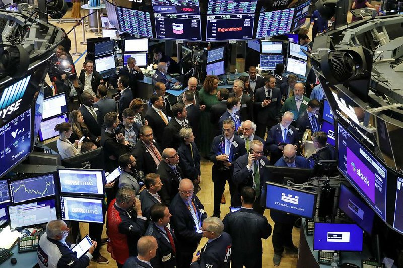 Traders gather Thursday on the floor of the New York Stock Exchange as they wait for Slack Technologies Inc. stock to begin trading. 