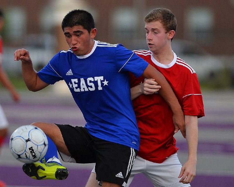The East’s Joe Pacheco of Jonesboro (left) battles for the ball with the West’s Elliott Hankins (right) of Little Rock Christian during the Arkansas High School Coaches Association Boys All-Star soccer game Friday at Estes Stadium in Conway. The East won 4-1. More photos from this game are available at arkansasonline.com/galleries.